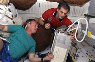 STS-89 Mission Specialists David Wolf and Andrew Thomas work on the Cocult experiment together, while onboard the middeck of the Orbiter Endeavour.